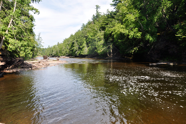 Lee Duquette feeling the water at Nawadaha Falls as it flows towards the river